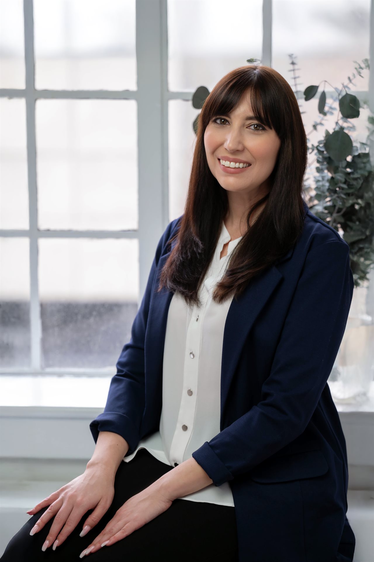 Valerie Lelia, founder of Still She Co  and author of Her, Reclaimed, seated by a bright window